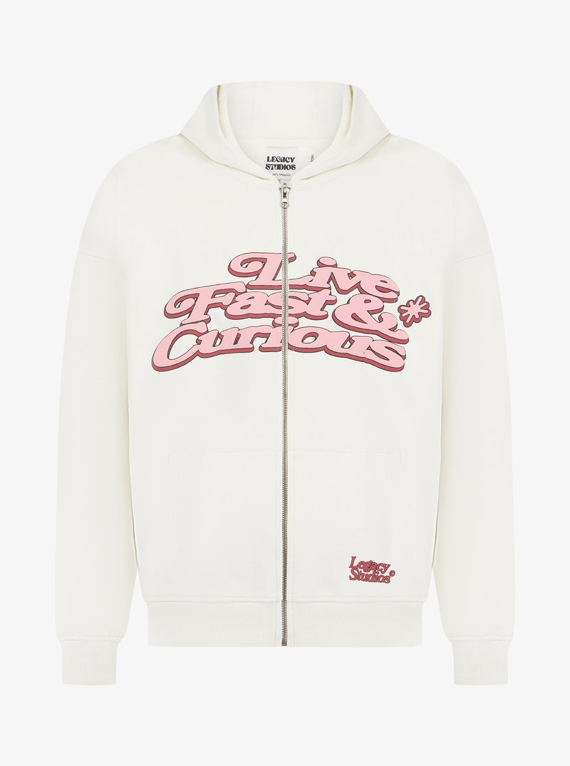 White zip-up hoodie with a large pink "Live Fast & Curious" graphic on the front, featuring a kangaroo pocket and ribbed cuffs.