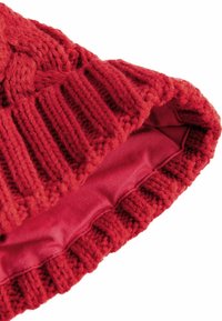 Bonnet en tricot rouge avec un design en câble et un revers côtelé. Doublure intérieure douce en tissu lisse.