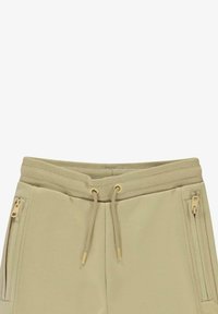 Khaki trainingsbroek met geribde tailleband, trekkoord en twee ritszakken aan de zijkant. Zachte stof met een gladde textuur.