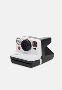 Appareil photo instantané Polaroid avec une façade blanche, une base noire, un objectif circulaire, un bouton rouge et une bande arc-en-ciel en accent. Forme compacte et rectangulaire.
