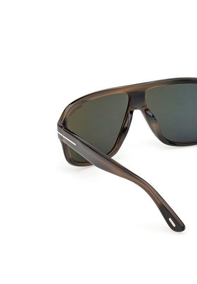 Gafas de sol carey marrón oscuro con grandes lentes cuadradas y una delgada franja blanca decorativa en la patilla.