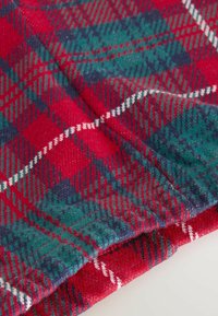 Tela de cuadros en rojo, verde y azul marino con una textura suave. Presenta un patrón de cuadros diagonal con acentos blancos a lo largo de las líneas.