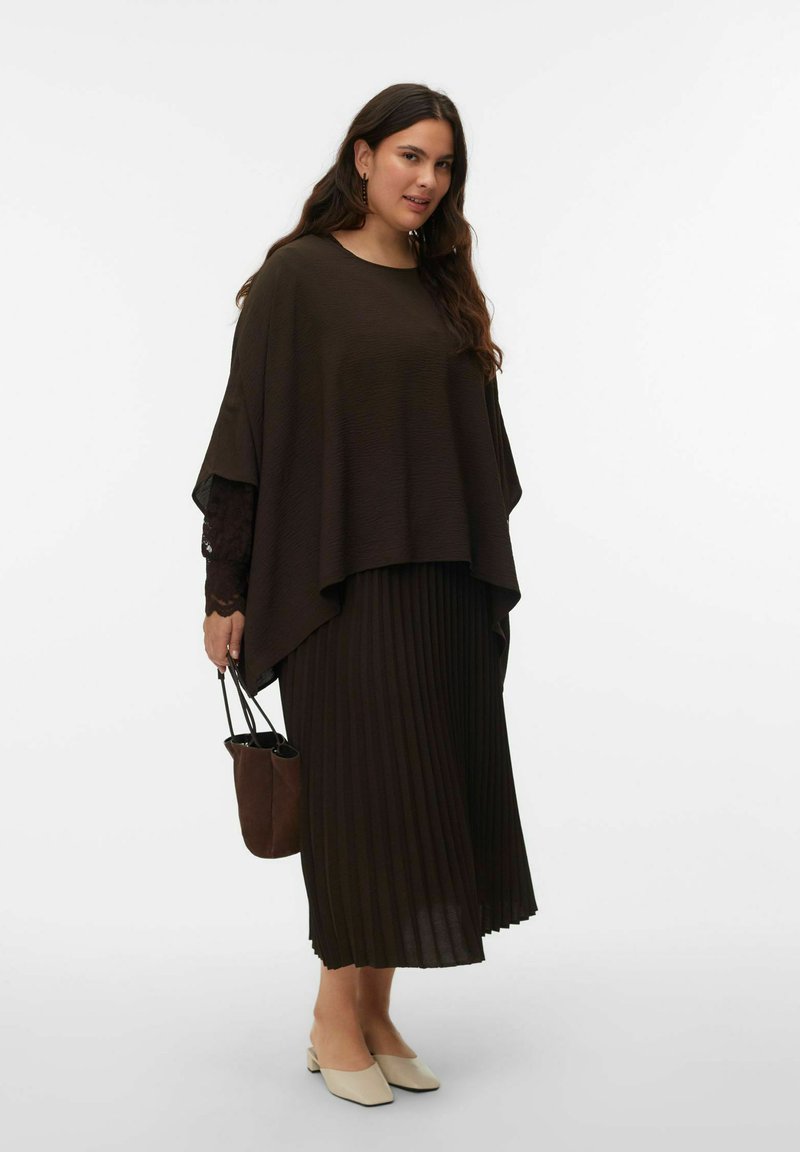 Jupe plissée marron associée à un haut marron ample. Comprend un sac à bandoulière marron et des chaussures de couleur crème. Texture lisse sur l'ensemble.