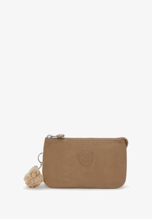 Pequeño pouch color beige con cierre, parche redondo del logo de Kipling y un llavero de mono peludo adjunto en el lado izquierdo.