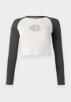 Maglietta a maniche lunghe tagliata con corpo grigio chiaro e maniche grigio scuro. Presenta una grafica di sole beige sul petto. Materiale in cotone.