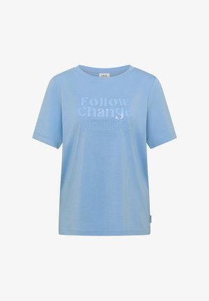 Camiseta de manga corta color azul claro con texto en relieve "Sigue el Cambio Bailando" y texto más pequeño debajo en el frente, cuello redondo.
