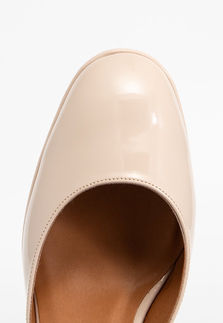 Beige Lacklederschuh mit abgerundetem Zehenbereich, glatter, glänzender Oberfläche und einem Ausschnitt-Design an der Vorderseite, das eine braune Innensohle zeigt.
