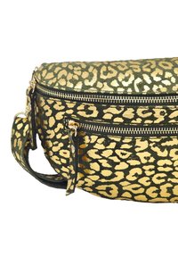 Sac à motifs léopard vert et or avec une forme arrondie, comportant deux zippers, un accastillage doré et une surface texturée.