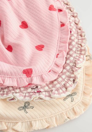 Ensemble de quatre sets de table en tissu : rose avec des cœurs, chocolat à carreaux, pêche clair avec des nœuds, tous présentant des bords ondulés et un coton texturé.