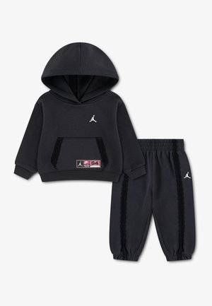 Czarny dres dziecięcy z bluzą z kapturem i spodniami typu jogger, oba z białym logo Jumpman i naszywkami.