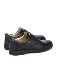 Chaussures en cuir noir avec une finition lisse, design à lacets, bout arrondi, intérieur rembourré et petit logo sur le côté.