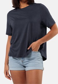 Navy blue short-sleeve t-shirt with a round neck, soft texture, relaxed fit, and side slits, paired with light denim shorts.