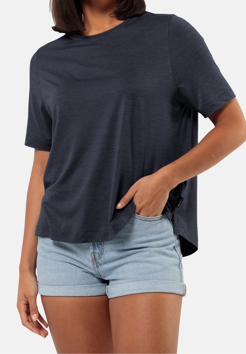 Navy blue short-sleeve t-shirt with a round neck, soft texture, relaxed fit, and side slits, paired with light denim shorts.