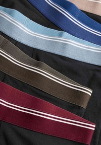 Fasce elastiche multicolori disposte piatte, caratterizzate da blu, blu scuro, marrone, nero, bordeaux e azzurro, con strisce bianche su ciascuna.