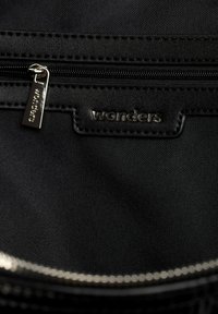 Czarna tkanina wewnętrzna o gładkiej fakturze, z zamkiem błyskawicznym i kieszenią. Na materiale jest przyszyta metka z napisem "wonders", metalowy suwak.