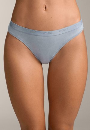 Helles blaues Baumwoll-Tanga mit glatter Textur, ausgestattet mit einem elastischen Bund, auf dem der Markenname "OYSHO" leicht eingeprägt ist.