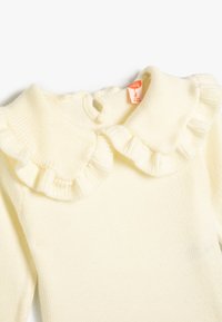 Hellgelber, gestrickter Pullover mit einem gerüschten Kragen und einer Knopföffnung auf der Rückseite. Weiche Textur mit einem einfachen Design, das für Kinder geeignet ist.