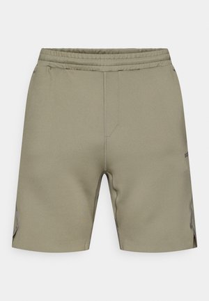 Olivově zelené šortky s elastickým pasem, bočními kapsami a hladkou texturou. Mají kontrastní švy a jemný detail loga.