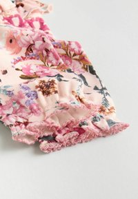 Tessuto a fantasia floreale con tonalità di rosa e viola. Presenta bordi arricciati con una finitura scallopata. Materiale morbido e leggero.
