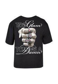 Black t-shirt featuring a graphic of a clenched fist adorned with multiple rings. Text reads "TOO Glam TO GIVE A Damn," in bold white letters.