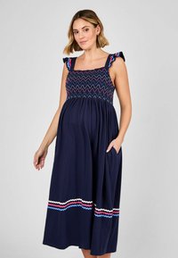 Abito premaman blu navy con spalline a volant, smock testurizzato nel corpino e dettagli a righe ondulate in rosa, blu e crema all'orlo.