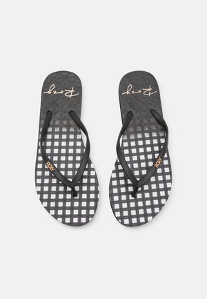 Svarte flip-flops med et rutenettmønster med alternerende svarte og hvite firkanter, teksturert fotseng og svarte stropper med et metallisk Roxy-logo.