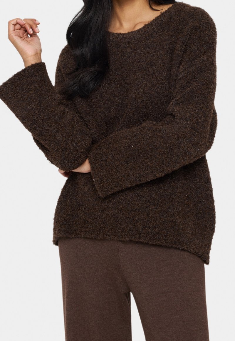Brun, fluffig stickad tröja med bred båtutskärning, långa ärmar och avslappnad passform, kombinerad med matchande bruna byxor.