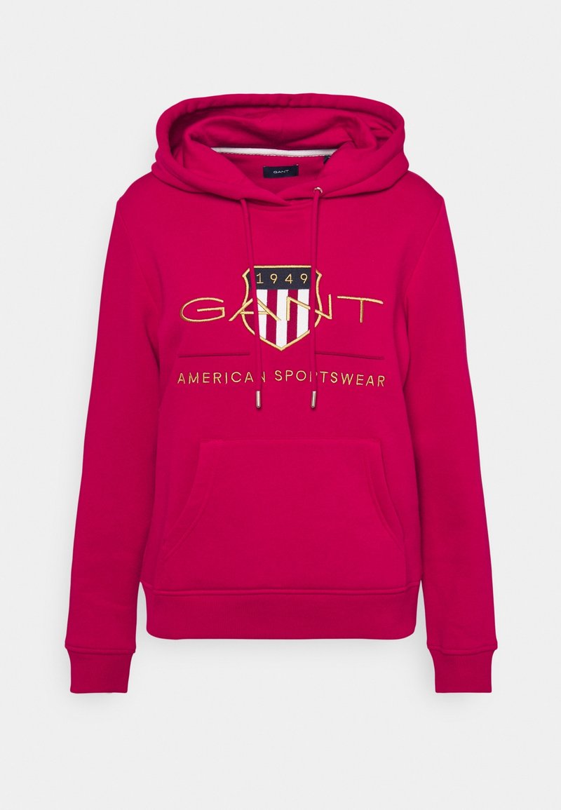 Sudadera con capucha rosa con un bolsillo frontal, que presenta un logo bordado en oro y colores, con el texto "AMERICAN SPORTSWEAR" debajo.