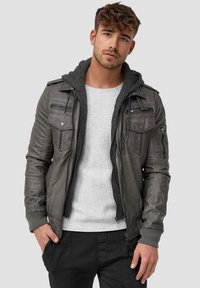 Chaqueta de cuero gris con bolsillos con cremallera, que incluye una capucha gris desmontable. Puños y dobladillo acanalados; acabado de cuero texturizado.