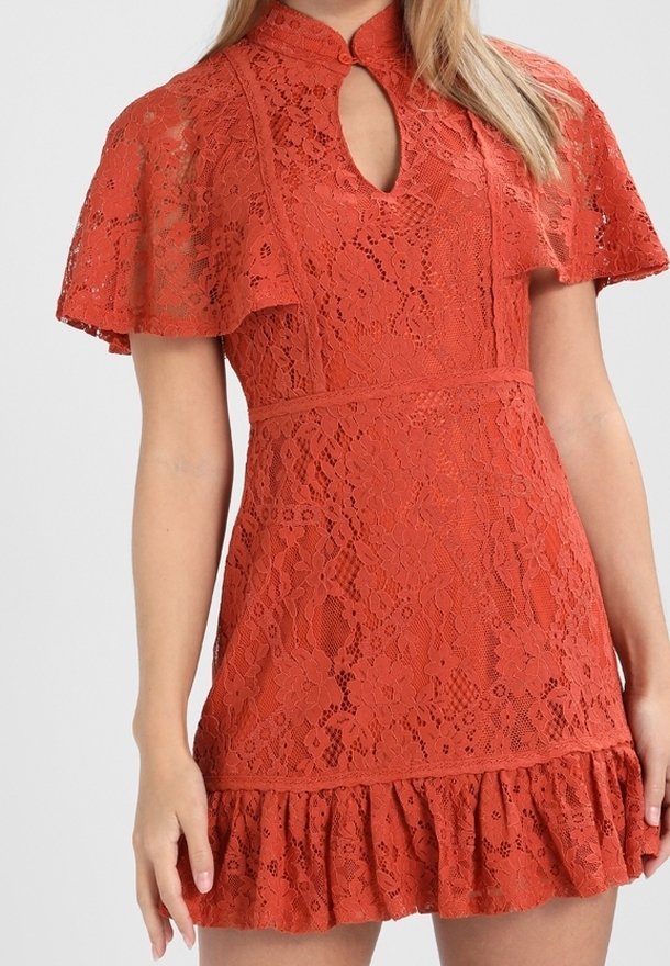 Red lace dress with a high collar, short flutter sleeves, keyhole neckline, fitted bodice, and a ruffled hem. Textured floral pattern throughout.