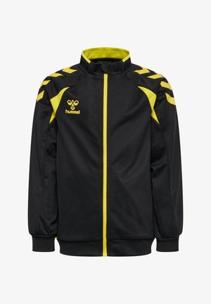 Zwart-geel sportjack met volledige rits aan de voorkant, hoge kraag, hummel-logo op de borst en chevronpatronen op de schouders.
