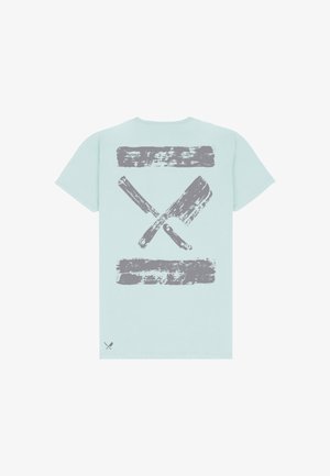 Camiseta azul clara con un gran gráfico gris desgastado de un cuchillo de cocina cruzado y un machete en la espalda.