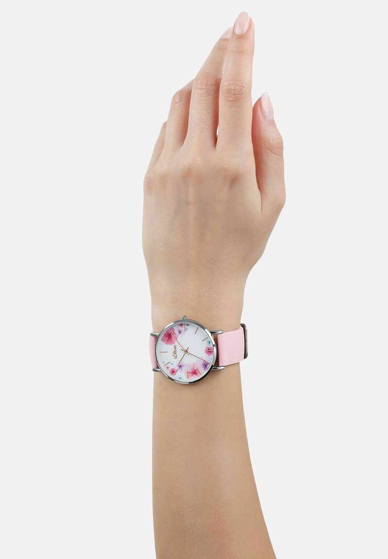 Kwarts horloge met een witte wijzerplaat met roze bloemenpatronen, zilveren uurmarkeringen en een lichtroze siliconen band.
