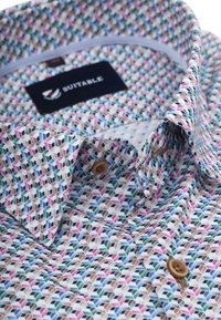 gepatroniseerde shirt met een geometrisch ontwerp in pastelkleuren, met een button-down kraag en een logolabel aan de binnenkant.