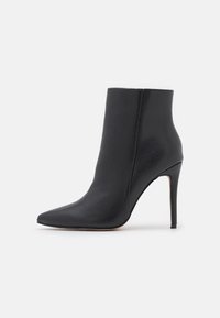 Stivale alla caviglia in pelle nera con punta affusolata e tacco a stiletto. Texture liscia senza hardware visibile o motivi. Design minimalista.