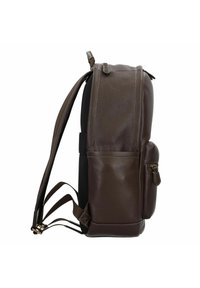 Sac à dos en cuir marron avec surface texturée, accents en maille noire, bretelles ajustables et poche zippée sur le côté. Présente un design robuste.