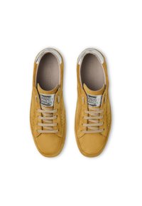 Sneakers gialli in suede con una consistenza morbida, dettagli in argento sul colletto e lacci beige. Dettagli perforati nella zona delle dita.