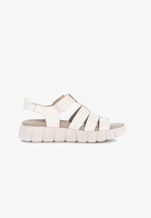 Sandale blanche en cuir à bout ouvert, avec semelle épaisse et rembourrée, bride ajustable et plusieurs larges lanières traversant le pied.