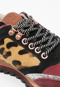 Sneaker multicolore con un pannello in stampa leopardata, suede nero, dettagli metallici, lacci rotondi e suola in gomma texturizzata.