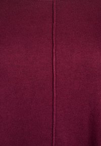 Burgunderfarbener Strickstoff mit einer vertikalen Naht in der Mitte, der eine gerippte Struktur aufweist und keine sichtbaren Beschläge oder Muster hat.