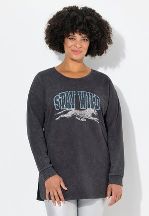 T-shirt nero a maniche lunghe con una stampa grafica di un ghepardo in salto e la scritta "STAY WILD" in blu. Vestibilità ampia, tessuto morbido.