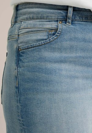 Light blue denim jeans featuring a fitted design, classic five-pocket styling, and contrast stitching along the seams.