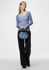 Šviesiai mėlynas raštuotas ilgomis rankovėmis viršus su kvadratiniu iškirpimu, derinamas su juodomis plačiomis kelnėmis ir mažąja mėlyna rankine. Lygus paviršius.