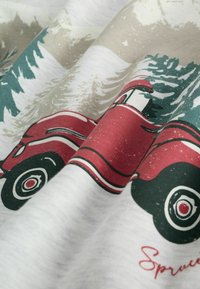 Ilustrácia červenej vintage dodávky na svetlo béžovej látke, s farebnými zelenými stromami a snehom, s textúrovanými detailmi a mäkkým bavlneným materiálom.