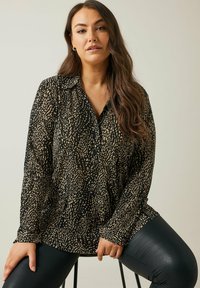 Schwarze Bluse mit einem gesprenkelten hellbraunen Muster, featuring lange Ärmel, eine durchgehende Knopfleiste und einen Kragen.