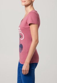 Rosa t-shirt med kort ärm och V-ringning, med en grafisk design i blå nyanser. Matchas med blå denim, mjukt bomullstyg.