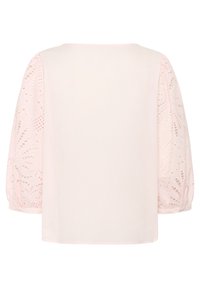 Ljust rosa blus med broderade spets puffärmar och en enkel, avslappnad passform. Kroppen är slät med en rundad halsringning.