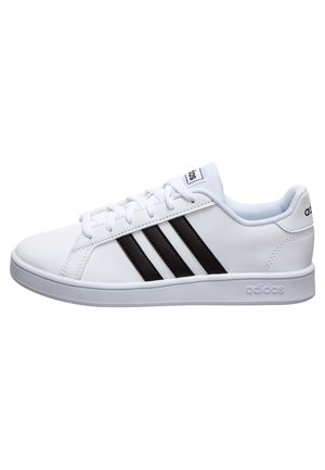 Zapatilla deportiva blanca con tres rayas negras, parte superior de material sintético suave, cuello acolchado y suela de goma. Diseño de cierre con cordones.