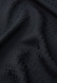 Black fabric with a smooth texture, featuring a subtle geometric pattern woven into the material, creating depth and visual interest.