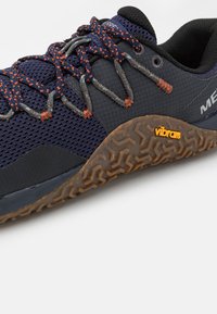 Parte superiore in rete blu e sintetico con accenti grigi, lacci multicolori e suola Vibram testurizzata con un motivo geometrico.